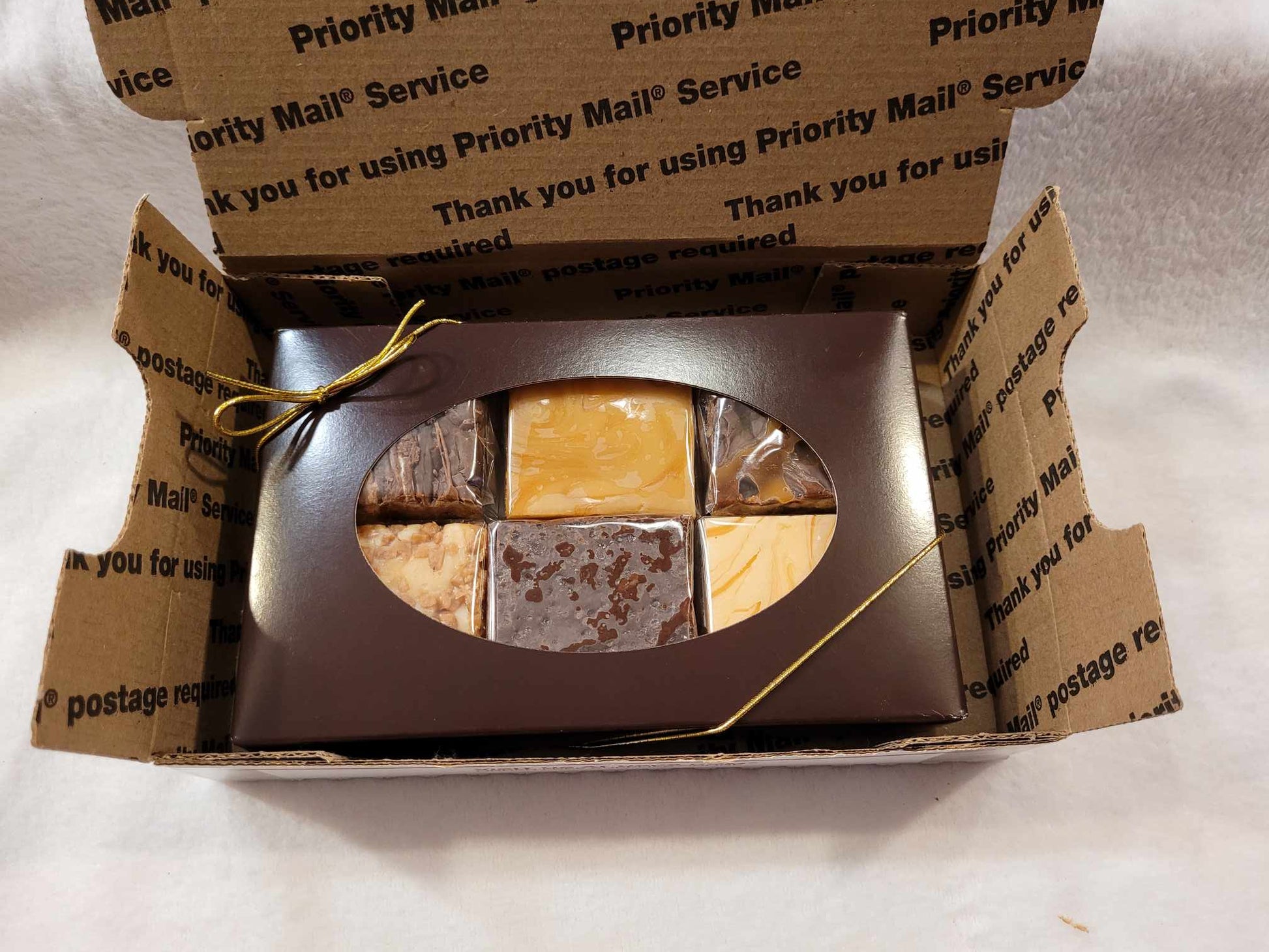 A 6 flavor fudge gift box in a Priority mail shipping box