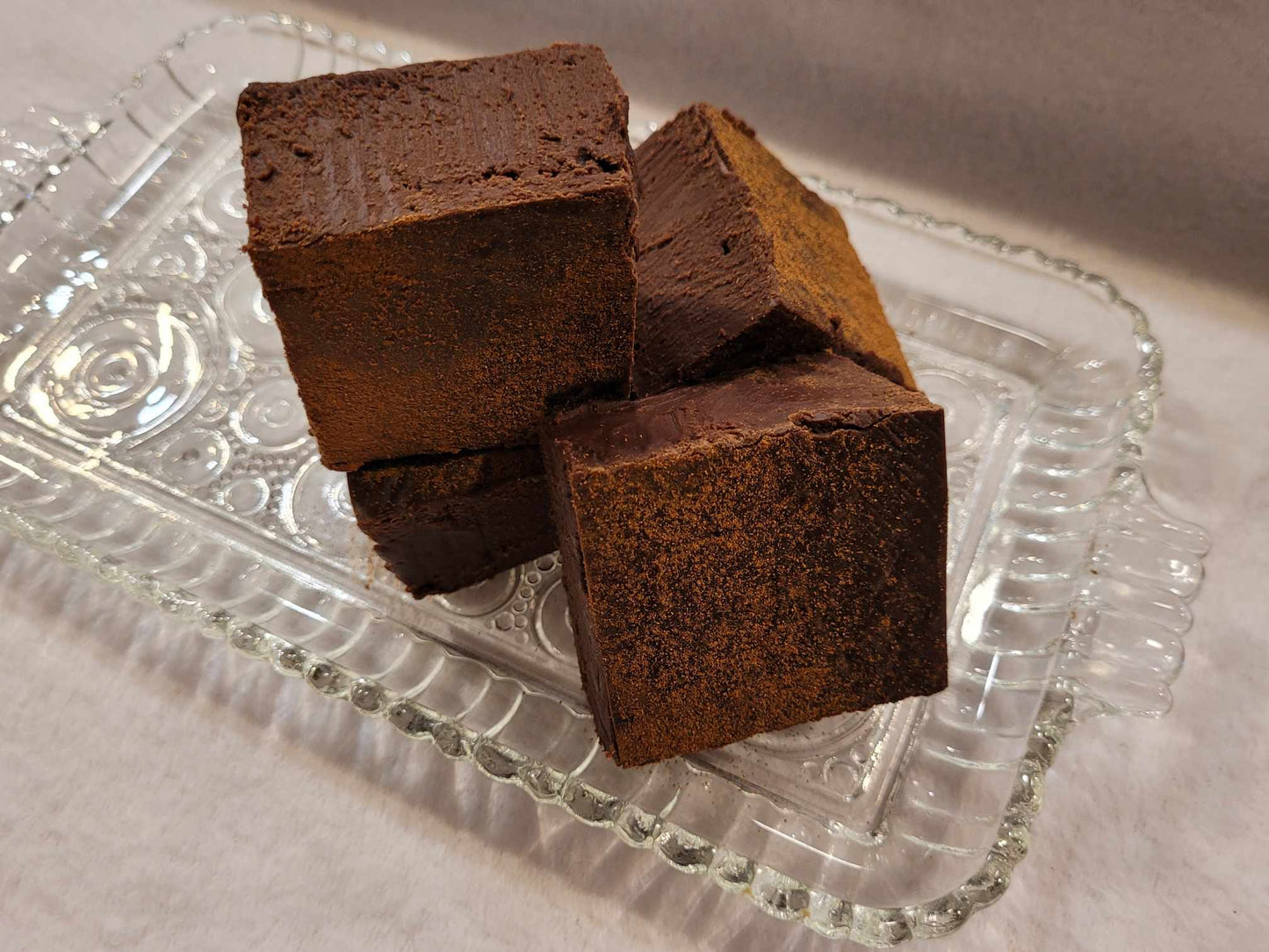 Three pieces of mexican hot chocolate fudge on a clear glass tray