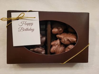 Box of chocolates with a 'Happy Birthday' card on a light background
